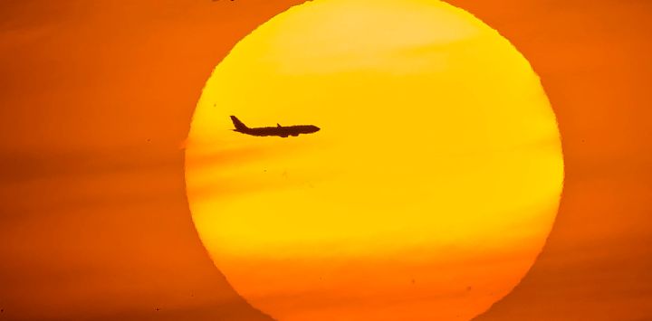 La silueta de un avión de pasajeros se recorta contra el sol poniente en el distrito de Eminonu de Estambul, Turquía.