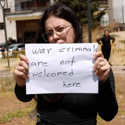 Una mujer sostiene un cartel mientras ella y otras personas se manifiestan contra el primer ministro israelí durante su visita a la aldea drusa de Majdal Shams en los Altos del Golán. Foto de Jalaa MAREY / AFP | Foto:AFP