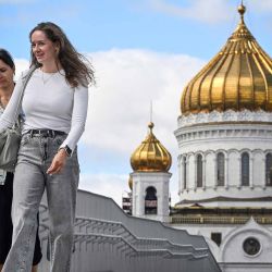 Mujeres caminan a lo largo de un puente sobre el río Moscova frente a la Catedral de Cristo Salvador en Moscú. Foto de Alexander NEMENOV / AFP | Foto:AFP