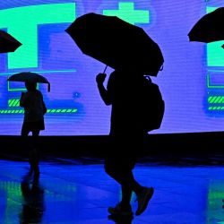Personas con paraguas caminan durante una tormenta en Beijing. Foto de Pedro PARDO / AFP | Foto:AFP
