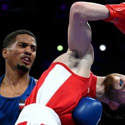 Yunior Alcántara Reyes de República Dominicana conecta un puñetazo contra Nijat Huseynov de Azerbaiyán en el combate de boxeo durante los Juegos Olímpicos de París. Foto de MOHD RASFAN / AFP | Foto:AFP