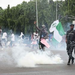 Manifestantes reaccionan mientras la policía nigeriana dispara botes de gas lacrimógeno durante la protesta para acabar con el mal gobierno en Abuja. Foto de Kola Sulaimon / AFP | Foto:AFP