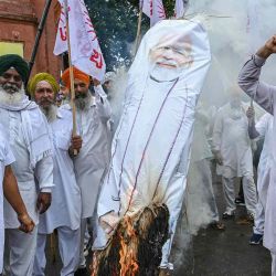 Los agricultores gritan consignas mientras queman una efigie del primer ministro de la India, Narendra Modi, durante una protesta. Foto de Narinder NANU / AFP | Foto:AFP