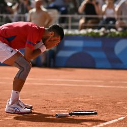El serbio Novak Djokovic reacciona tras vencer al español Carlos Alcaraz en su final de tenis individual masculino en la cancha Philippe-Chatrier en el Estadio Roland-Garros durante los Juegos Olímpicos de París 2024, en París. | Foto:CARL DE SOUZA / AFP