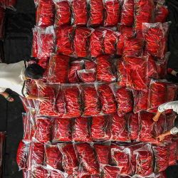Los trabajadores clasifican los chiles picantes para su entrega en un centro de compra de chiles en el municipio de Chongqing, en el suroeste de China. | Foto:AFP