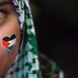 Una mujer con una pegatina de la bandera palestina en la cara observa durante una manifestación en Kuala Lumpur, Malasia. | Foto:Arif Kartono / AFP