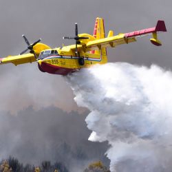 Imagen de un avión canadiense de extinción de incendios rociando agua para extinguir un incendio forestal, en Sibenik, Croacia. | Foto:Xinhua/Hrvoje Jelavic