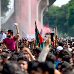 Manifestantes antigubernamentales ondean la bandera nacional de Bangladesh mientras celebran en la zona de Shahbag, cerca de la Universidad de Dhaka, en Dhaka. Las protestas en Bangladesh, que comenzaron como manifestaciones lideradas por estudiantes contra las normas de contratación del gobierno en julio, culminaron con la huida del primer ministro y el anuncio de los militares de que formarían un gobierno interino. | Foto:MUNIR UZ ZAMAN / AFP
