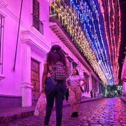 Mujeres se toman fotografías en una calle iluminada con los colores de la bandera venezolana en Caracas. El número de muertos en Venezuela en las protestas de la oposición contra la disputada reelección del presidente Nicolás Maduro ha aumentado a 24, según la ONG venezolana de derechos humanos Provea. | Foto:JUAN BARRETO / AFP