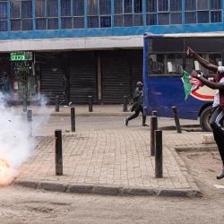 Un manifestante que sostiene una bandera de Kenia salta cuando explota un bote de gas lacrimógeno durante una manifestación contra el gobierno en Nairobi, Kenia. La policía de Kenia disparó ráfagas de gas lacrimógeno en la capital, Nairobi, hiriendo a varios periodistas, mientras pequeños grupos de manifestantes se reunían en lo que se anunció como un nuevo día de acción contra el asediado presidente William Ruto. | Foto:Patrick Meinhardt / AFP