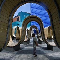 Una mujer camina en una zona de descanso en un centro comercial de Pekín, China. | Foto:PEDRO PARDO / AFP