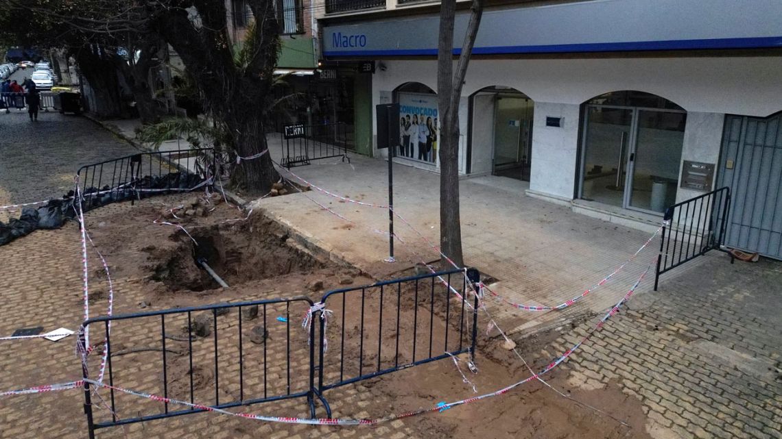 Aerial view of a hole in a street in front of a branch of Banco Macro in San Isidro, Buenos Aires Province, Argentina, on August 8, 2024. Argentine authorities discovered Thursday, in an unusual incident, an elaborate tunnel more than 150 meters long, presumably built to rob a bank in the town of San Isidro, a northern suburb of Buenos Aires, according to a local police statement. 