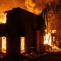 Una casa arde durante un incendio forestal en Varnavas, al norte de Atenas, Grecia. | Foto:Angelos Tzortzinis / AFP