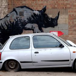 Una obra de arte del artista callejero Banksy, la octava que se lanza en ocho días, muestra a un rinoceronte subido a un automóvil en una pared en Charlton, Londres. El artista confirmó que la obra es suya después de publicar una imagen de ella en la aplicación de redes sociales Instagram. | Foto:Adrian Dennis / AFP