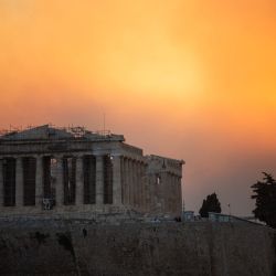 Esta fotografía muestra el templo del Partenón en la cima de la colina de la Acrópolis en medio de una nube de humo provocada por un incendio forestal, en Atenas, Grecia. | Foto:Angelos Tzortzinis / AFP
