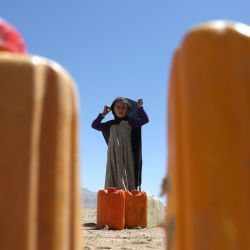 Imagen de una niña permaneciendo frente a bidones con agua en un sitio de reubicación para sobrevivientes de inundaciones en Firoz Koh, en la provincia de Ghor, Afganistán. Desde mayo, Afganistán ha sufrido varias inundaciones letales que han causado más de 400 muertes en todo el país. | Foto:Xinhua/Saifurahman Safi