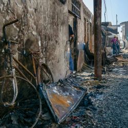 Una mujer joven pasa junto a una bicicleta quemada mientras los residentes inspeccionan los daños provocados por un incendio que destruyó cientos de viviendas en el densamente poblado subdistrito de Manggarai, en Yakarta, Indonesia. | Foto:BAY ISMOYO / AFP