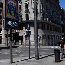 Una pareja pasa junto a un termómetro callejero que marca 45 grados centígrados mientras España se enfrenta a la cuarta ola de calor del verano, en la ciudad de Bilbao. | Foto:ANDER GILLENEA / AFP