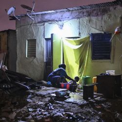 Una madre baña a su bebé en el exterior de una casa en Adjame, Abiyán, siete días después de que varias casas fueran demolidas en una operación policial. Desde enero, las autoridades han llevado a cabo demoliciones masivas en los precarios barrios de chabolas de la metrópoli de seis millones de personas antes de expulsar por la fuerza a sus residentes. | Foto:Issouf Sanogo / AFP