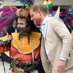 El príncipe Harry, duque de Sussex, posa para una selfie con un artista mientras su esposa Meghan observa durante una visita al Centro Nacional de las Artes en Bogotá, Colombia. | Foto:RAUL ARBOLEDA / AFP