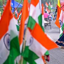 Los vendedores esperan a los clientes para vender la bandera nacional de la India en una carretera antes de las celebraciones del Día de la República del país en Nueva Delhi. | Foto:Sajjad Hussain / AFP