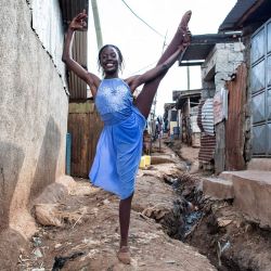 Una estudiante de ballet del Proyecto Elimu, con sede en Kibera, posa antes de un espectáculo público en Kibera. El Proyecto Elimu, una organización comunitaria sin fines de lucro, ofrece programas de educación artística y deportiva después de la escuela para jóvenes de entre 3 y 22 años. Durante las vacaciones escolares, el centro organiza actuaciones callejeras para alentar a más estudiantes a unirse al centro de danza. Kibera es el barrio marginal más grande de Nairobi, uno de los más grandes de África. | Foto:GORDWIN ODHIAMBO / AFP