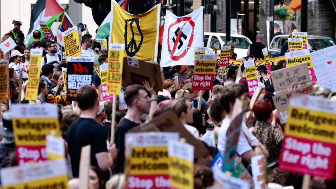 People hold anti-racist placards as they take part in a 'Stop the Far-right' demonstration on a National Day of Protest, outside of the headquarters of the Reform UK political party, in London on August 10, 2024. 