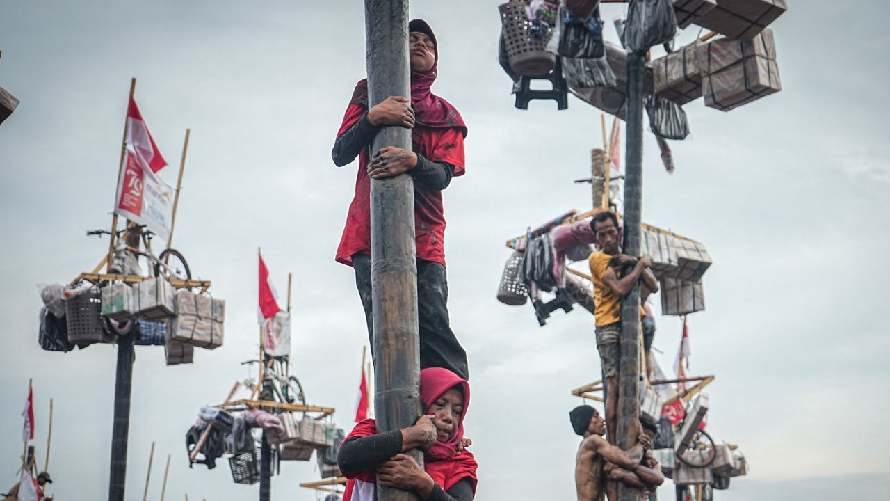 Las mujeres participan en un juego tradicional llamado "Panjat Pinang" para trepar un poste de árbol de 4 metros de altura untado con aceite para recolectar premios en la cima como parte de la celebración anual del 79º Día de la Independencia de Indonesia en Palembang, Sumatra del Sur. | Foto:Al ZULKIFLI / AFP