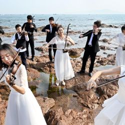 Imagen de estudiantes de la Universidad Oceánica de China realizando una presentación en el punto escénico del Muelle de Zhanqiao, en la provincia de Shandong, en el este de China. | Foto:Xinhua/Li Ziheng