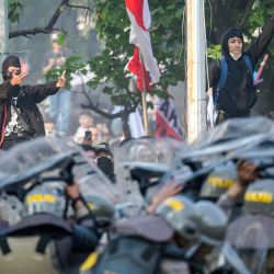 Manifestantes hacen un gesto durante los enfrentamientos con la policía frente al edificio del Parlamento en Yakarta, Indonesia, durante una protesta contra una medida para revertir la decisión de la Corte Constitucional que altera las reglas de elegibilidad de los candidatos en una elección clave a finales de este año. | Foto:BAY ISMOYO / AFP