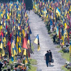 La gente camina entre las tumbas en el cementerio del Campo de Marte para conmemorar a los soldados caídos con motivo del Día de la Independencia de Ucrania, en medio de la invasión rusa de Ucrania. | Foto:STANISLAVSKY / AFP