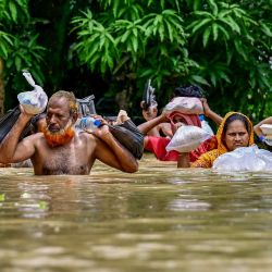 Personas que transportan material de socorro atraviesan las aguas de las inundaciones en Feni, en el sureste de Bangladesh. Casi 300.000 bangladesíes se refugiaban en refugios de emergencia tras las inundaciones que inundaron vastas zonas del país del sur de Asia, según informaron los responsables de la gestión de desastres. Las inundaciones fueron provocadas por las fuertes lluvias monzónicas y han matado al menos a 42 personas en Bangladesh y la India desde principios de semana, muchas de ellas en deslizamientos de tierra. | Foto:MUNIR UZ ZAMAN / AFP