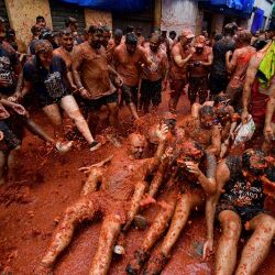 Los asistentes participan en la batalla de comida anual de la "Tomatina" en la ciudad de Buñol, en el este de España. | Foto:Jose Jordan / AFP