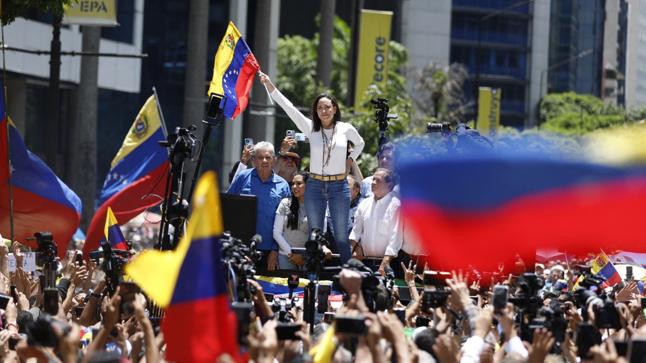 La líder opositora venezolana María Corina Machado ondea una bandera nacional durante una manifestación en Caracas. Los partidarios de la oposición venezolana se manifestaron un mes después de la disputada reelección del presidente Nicolás Maduro, quien blindó su gabinete con un hombre fuerte al mando de la ley y el orden. | Foto:Pedro Rances Mattey / AFP