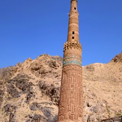 Un hombre afgano armado se encuentra cerca del antiguo minarete de Jam, en el distrito de Shahrak, provincia de Ghor. | Foto:Mohsen Karimi / AFP