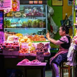 Un vendedor de frutas espera a sus clientes en Shanghái. | Foto:Hector Retamal / AFP