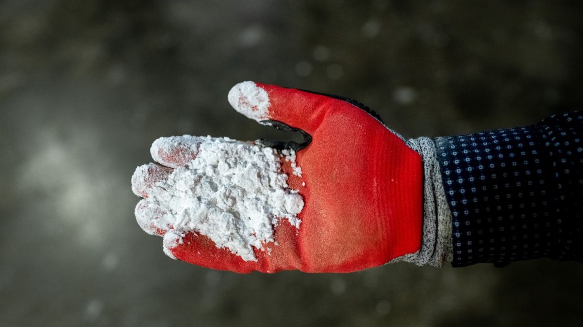 A worker holds lithium hydroxide. The material will be key to the energy transition, and a number of start-ups are working on new techniques to produce it.