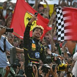 El piloto de Ferrari, Charles Leclerc, se toma una selfie con sus seguidores después de ganar la carrera del Gran Premio de Fórmula Uno de Italia en el circuito Autodromo Nazionale Monza, en Monza. | Foto:GABRIEL BOUYS / AFP
