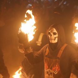 Imagen de un joven portando una máscara mientras sostiene bolas de fuego durante la celebración de 102 años de la tradición de "Las Bolas de Fuego", en el municipio de Nejapa, en el departamento de San Salvador, El Salvador. | Foto:Xinhua/Alexander Peña
