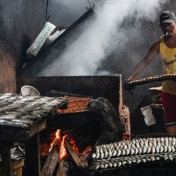 Un hombre prepara pescado ahumado en Rosario, provincia de Cavite, Filipinas. | Foto:JAM STA ROSA / AFP