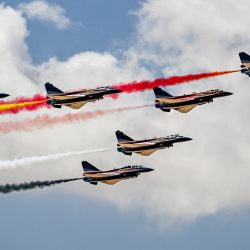 Aviones de combate Chengdu J-10 Vigorous Dragon del equipo de acrobacias aéreas Ba Yi de China liberan humo mientras realizan maniobras durante el primer Salón Aeronáutico Internacional de Egipto en el Aeropuerto Internacional de Alamein en Alamein, en el norte de Egipto. | Foto:Khaled Desouki / AFP