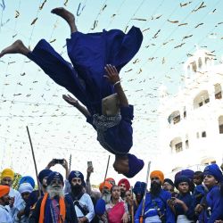 Un joven sij realiza un 'Gatka', una antigua forma de artes marciales sijs, durante una procesión religiosa con motivo del aniversario de la instalación del libro sagrado sij Guru Granth Sahib en el Templo Dorado de Amritsar, India. | Foto:Narinder Nanu / AFP
