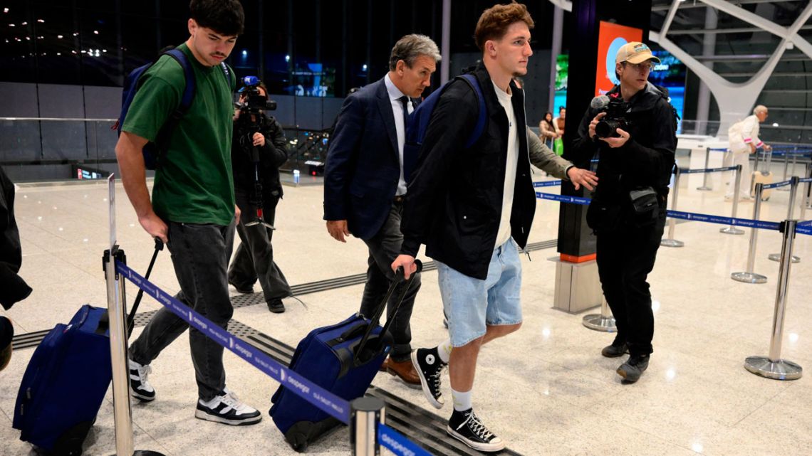 French rugby players Hugo Auradou (left) and Oscar Jégou (second right) and their lawyer Rafael Cúneo Libarona (Ccentre), walk before taking a flight to France at Ezeiza International Airport, Buenos Aires Province, Argentina on September 3, 2024. 