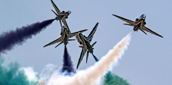 Los aviones de entrenamiento BAE Hawk del equipo acrobático Saudi Falcons de la Real Fuerza Aérea Saudita liberan humo mientras realizan maniobras durante el primer Salón Aeronáutico Internacional de Egipto en el Aeropuerto Internacional de Alamein en Alamein, en el norte de Egipto.