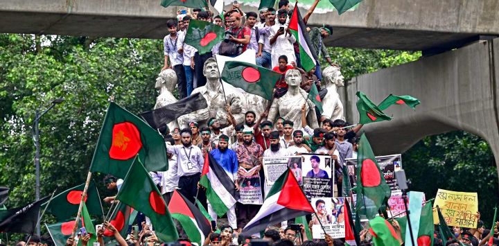 Manifestantes ondean la bandera nacional de Bangladesh durante la Marcha de los Mártires, una manifestación organizada por Estudiantes Contra la Discriminación para conmemorar el primer mes del derrocamiento de la ex primera ministra del país, Sheikh Hasina, en Dhaka.