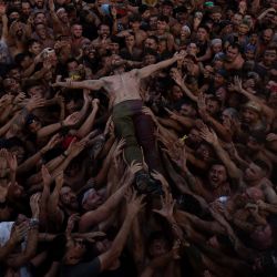 Un hombre salta entre la multitud durante la tradicional fiesta del Cascamorras, en Baza, cerca de Granada, España. | Foto:JORGE GUERRERO / AFP