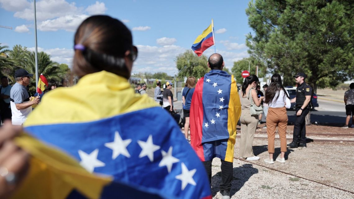 Supporters wrapped in Venezuelan flags gather upon the arrival of Venezuelan opposition presidential candidate for the Plataforma Unitaria Democrática party, Edmundo González Urrutia at Madrid's Torrejón de Ardoz military airport on September 8, 2024.