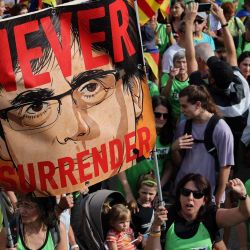 Los participantes sostienen una pancarta con el líder catalán Carles Puigdemont en la que se lee "Nunca te rindas" mientras marchan durante las celebraciones de la "Diada", el día nacional de Cataluña en Barcelona. | Foto:LLUIS GENE / AFP