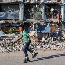 Un niño patina frente a un edificio destruido en un campamento que alberga a personas desplazadas por el conflicto en Jabalia, en el norte de la Franja de Gaza, en medio de la guerra en curso en el territorio palestino entre Israel y Hamás. | Foto:OMAR AL-QATTAA / AFP
