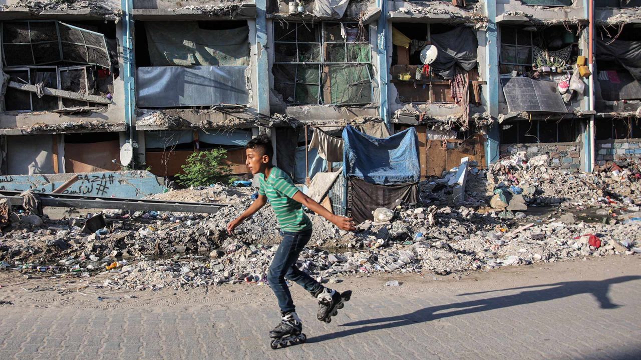 Un niño patina frente a un edificio destruido en un campamento que alberga a personas desplazadas por el conflicto en Jabalia, en el norte de la Franja de Gaza, en medio de la guerra en curso en el territorio palestino entre Israel y Hamás. | Foto:OMAR AL-QATTAA / AFP